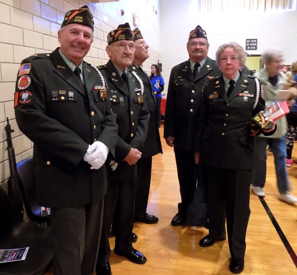 MARGARET DOWNING, PHOTO - The Journal. Shown from left: prior to the start of the “Tribute to Veterans” Nov. 10 are color guard members of the Clifford Johnson V.F.W. Post No. 9759 with keynote speaker Mary Nicholls, John Paddock, Glenn Widner, Marvin Mathees, Phjilip Pfeifer, and Nicholls. 