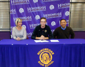JEAN SEEGERS, PHOTO - The Herald. Seated between his parents, Nicole and Matt Hedges, Hononegah High School Senior Max Miller recently signed a National Letter of Intent to play basketball at Cedarville University in Ohio next fall. 