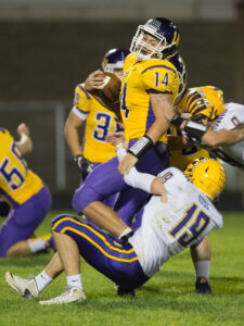 Belvedere quarterback Austin Revolinski (14) gets pummeled by Hononegah's Nick Kerska (19) and Bannon Powell (9) during the second quarter of the varsity football match up at Belvidere High School in Belvidere on Friday, Sep. 25, 2015. Erik Anderson | Belvidere Daily Republican
