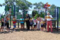 ANNE EICKSTADT PHOTO Belvidere Daily Republican
	Mayor Mike, Officer Tim, and kids at the General Mills Playground share quality reading time for the Read 815 Challenge.