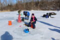 ANNE EICKSTADT PHOTO Belvidere Republican
	Gianna Roby, age 10, and Helena Roby, age 7 ½, are enjoying their ice fishing experience while Tod Todd (in blue) uses the Vex Box to spot fish.