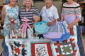 SUBMITTED PHOTO The Gazette
	From left: Sandra Elliott, Lola Moist, Vi Johns, and Martha Gale show off items you will see at the Nov. 9 Holiday House Bazaar at the Pecatonica United Methodist Women. Quilt raffle tickets are available now and they will draw at noon during the bazaar.