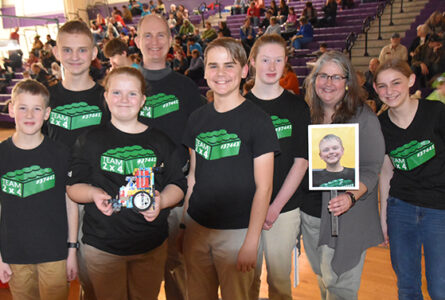 SUBMITTED PHOTO The Gazette
	Team 2x4 a successful robot run. From left: Mason Williams, Tim Walton, Bethany Walton, Coach Kent Walton, Evan Schneider, Halee Williams, Coach Heather Schneider, Isaac Bentley (in the photo being held), and student mentor Kelby Schneider celebrate.